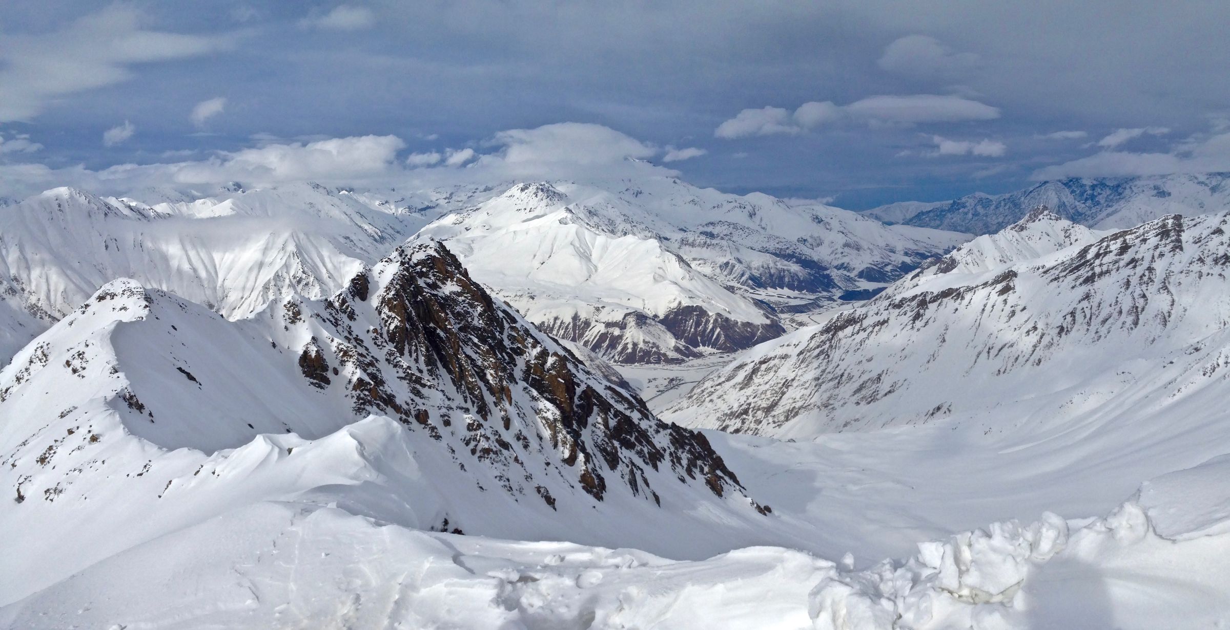 Gudauri snow peaks, the ski line cut small against a blue-white wall.
