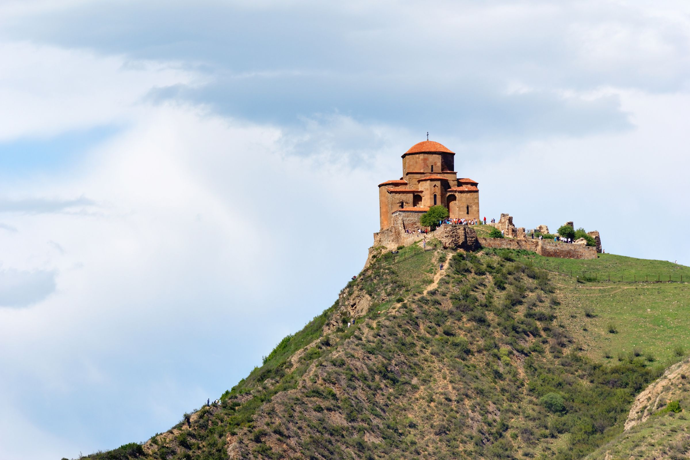 Jvari Monastery on its hill above the confluence of two rivers, stone against a wide Georgian sky.