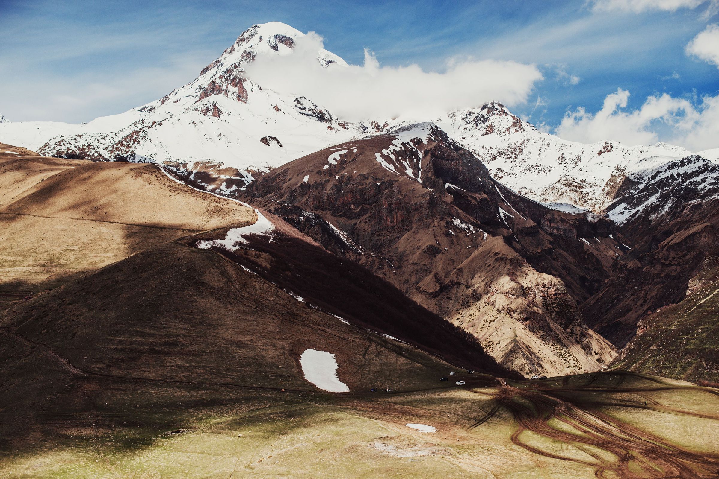 Mount Kazbek, a white pyramid above dark ridges, the summit catching weather.