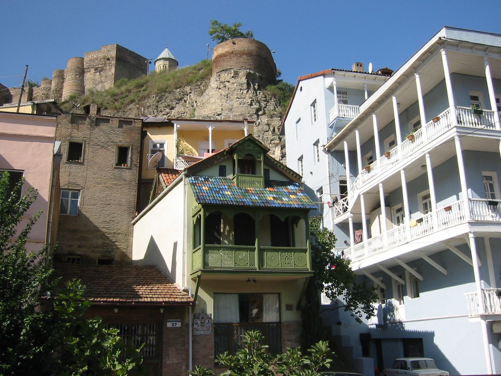 Tbilisi old town, carved wooden balconies and hanging laundry, a city arguing with its own hills.